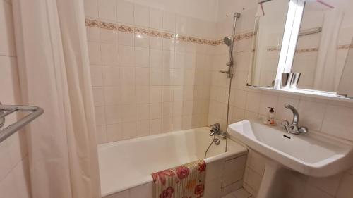 une salle de bain avec une baignoire, un lavabo et un miroir dans l'établissement Eperon 2 - F4 - Studio lumineux - 6 pers, à Les Deux Alpes