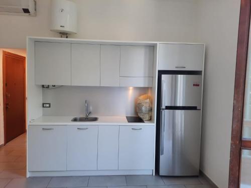 ミラノにあるSmart Central Apartments Doriaのキッチン(白いキャビネット、ステンレス製の冷蔵庫付)