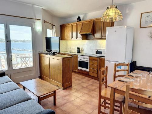 a kitchen with a refrigerator and a table with a dining room at F98. Vistas al mar en Fornells! in Fornells