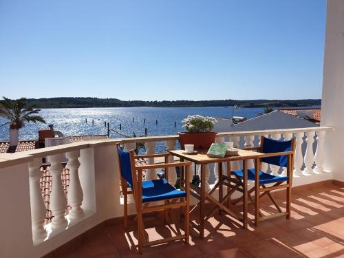 a table and chairs on a balcony with a view of the water at F98. Vistas al mar en Fornells! in Fornells