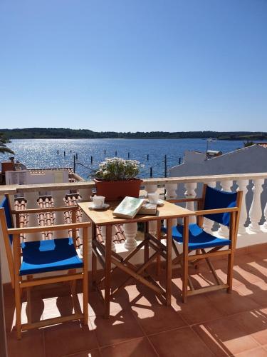 a table and chairs on a balcony with a view of the water at F98. Vistas al mar en Fornells! in Fornells
