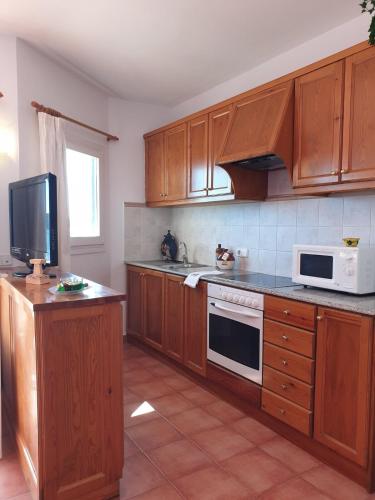 a kitchen with wooden cabinets and a white microwave at F98. Vistas al mar en Fornells! in Fornells