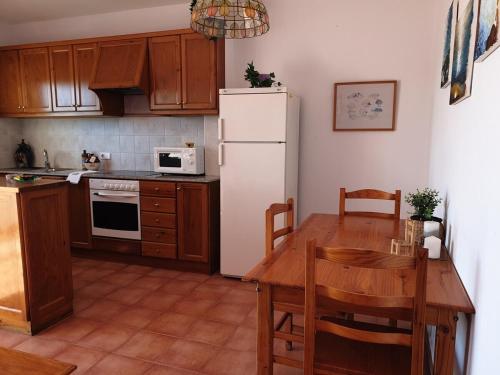 a kitchen with a table and a white refrigerator at F98. Vistas al mar en Fornells! in Fornells