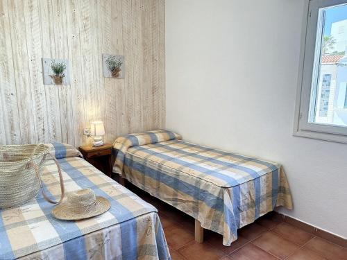 a room with two beds and a hat on a table at F98. Vistas al mar en Fornells! in Fornells