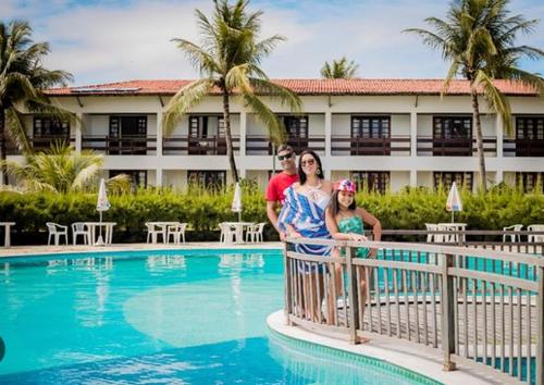 um homem e uma mulher em cima de uma vedação junto a uma piscina em Pontal do Atlântico Resort em Natal