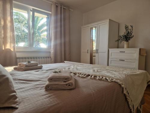Un dormitorio blanco con toallas en una cama en House Olive Garden Strunjan, en Strunjan