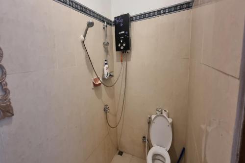 a bathroom with a shower and a toilet in it at Onion Garden And Natural Hotspring in Kubupenlokan