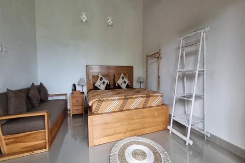 a bedroom with a bed and a couch at Onion Garden And Natural Hotspring in Kubupenlokan