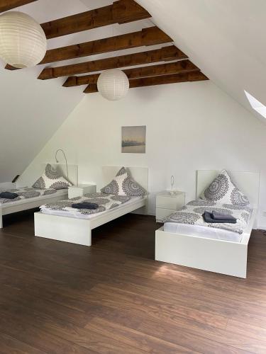 2 camas en una habitación con suelo de madera en Modernes Ferienhaus mit 2 Balkonen, Terrasse und Garten !, en Bochum