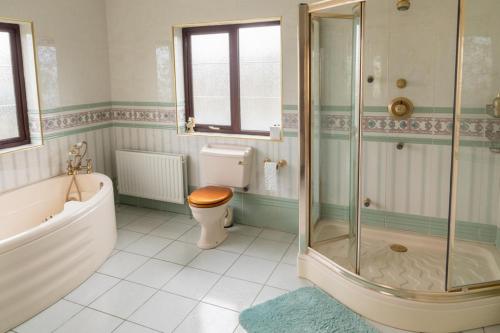 a bathroom with a tub and a toilet and a shower at Spacious House in beautiful Malin Head in Keenagh