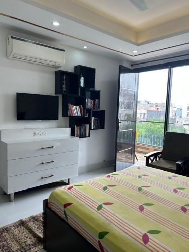 1 dormitorio con 1 cama, vestidor y TV en Shiv dham, en Nueva Delhi