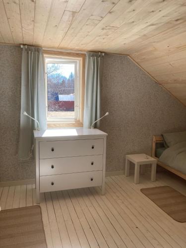 a bedroom with a white dresser and a window at Familjehuset Sunnemo in Sunnemo