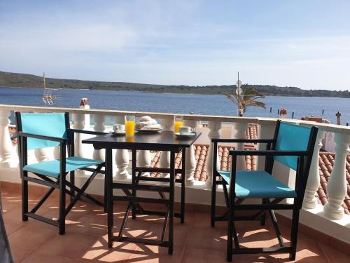 a table and chairs on a balcony overlooking the water at F76. Vistas al mar en Fornells! in Fornells