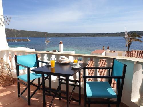 una mesa y sillas en un balcón con vistas al agua en F76. Vistas al mar en Fornells!, en Fornells