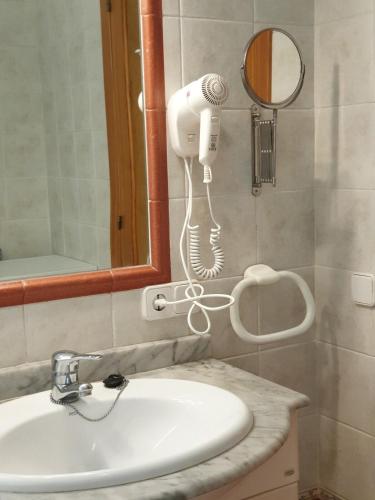 a bathroom with a sink and a hair dryer at F76. Vistas al mar en Fornells! in Fornells