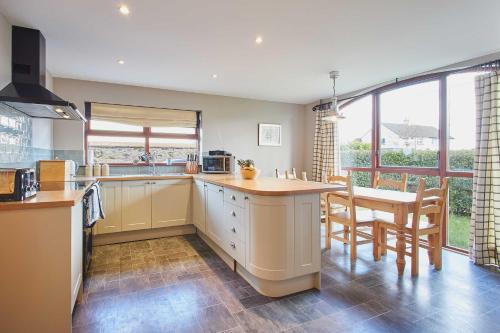 a kitchen with a counter and a table and chairs at Host & Stay - The Coach House in Beal