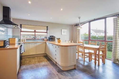 Una cocina con encimera, mesa y sillas. en Host & Stay - The Coach House, en Beal