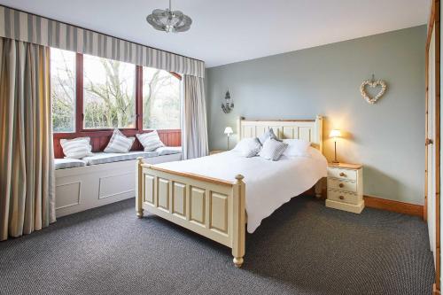 Un dormitorio con una cama grande y una ventana. en Host & Stay - The Coach House, en Beal