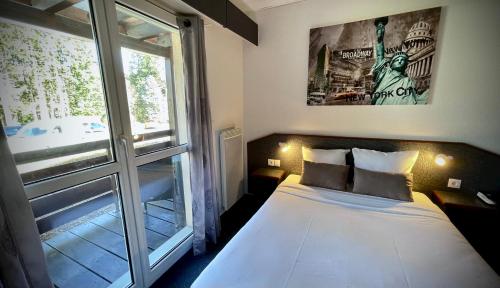 a bedroom with a bed and a large window at Hôtel Restaurant La Vallée Noble in Soultzmatt