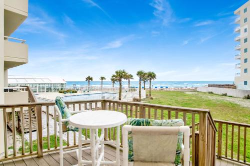 a balcony with a table and chairs and the beach at Perdido Sun Unit 116 in Pensacola