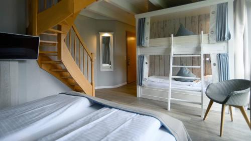 a bedroom with two bunk beds and a staircase at Hotel Am Medemufer in Otterndorf