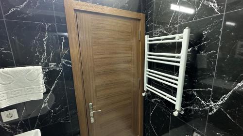 a bathroom with a wooden door and a black marble wall at Green Star Pera Hotel in Istanbul