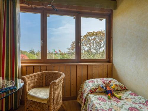 a room with a bed and a chair and two windows at Active Hotel Paradiso in Peschiera del Garda