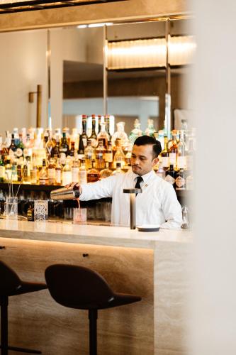 a man standing behind a bar with a bartender at Boutique Hotel Beaumont Maastricht in Maastricht