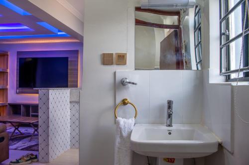 a bathroom with a sink and a mirror at Equine Hotel in Ruiru