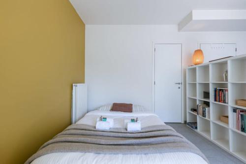 a bedroom with a large bed with white shelves at Comfortable studio with terrace in Antwerp in Antwerp