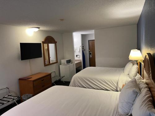 a hotel room with two beds and a television at Columbus Inn in Columbus