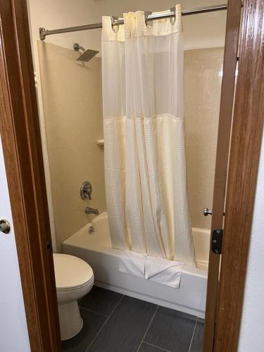 a bathroom with a toilet and a shower curtain at Columbus Inn in Columbus