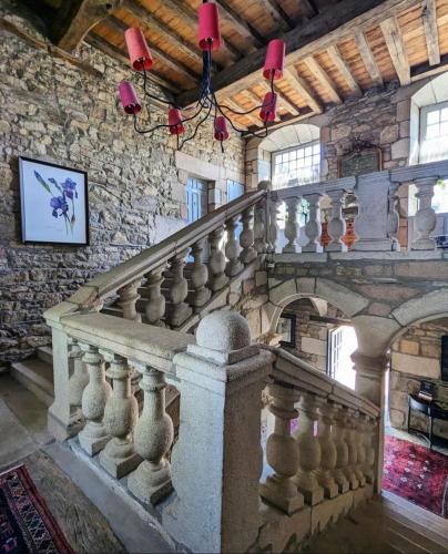 a stone staircase in a building with red lights at Manoir De Keringant in Saint-Quay-Perros