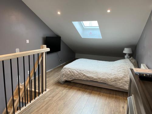 a small bedroom with a bed and a skylight at STUDIO proche aéroport in Bouguenais