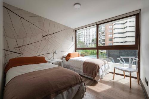 um quarto com 2 camas e uma grande janela em Edificio HOME em Santiago