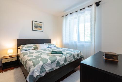 um quarto com uma cama, uma secretária e uma janela em Apartment Laurus em Vantacići