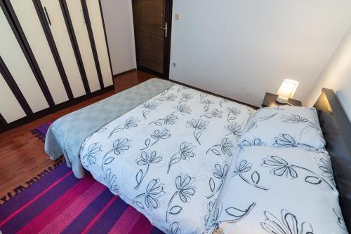 uma cama num quarto com um cobertor e almofadas em Apartment Laurus em Vantacići