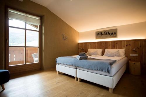 a bedroom with a bed and a large window at Schneckenhaus Dachstein West in Russbach am Pass Gschütt