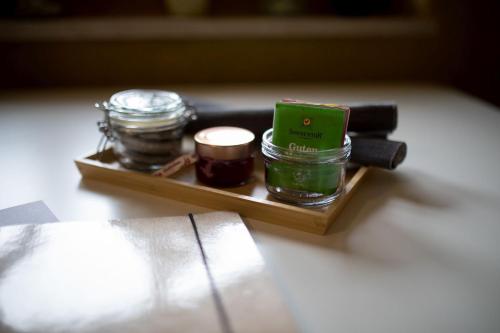 a small wooden tray with jars and a candle at Schneckenhaus Dachstein West in Russbach am Pass Gschütt