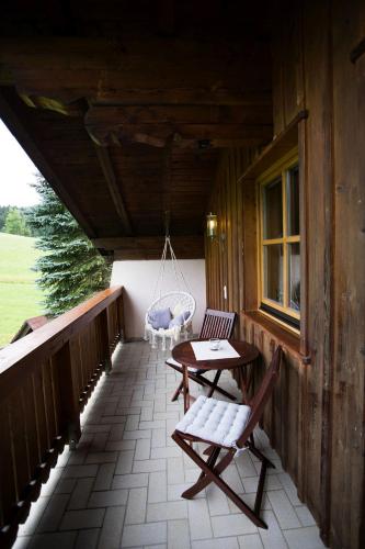 a porch of a cabin with a table and chairs at Schneckenhaus Dachstein West in Russbach am Pass Gschütt