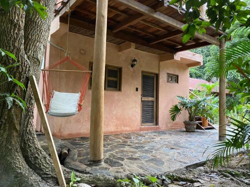 a porch of a house with a hammock hanging from a tree at Salvia Madre Hotel Boutique in Guachaca