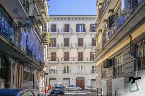 a tall white building with cars parked in front of it at Hotiday Room Collection - Napoli Sant'Arcangelo in Naples