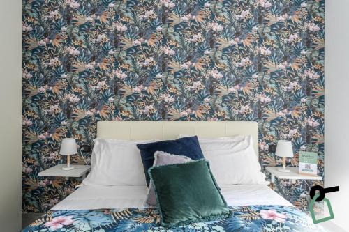 a bedroom with a bed with a floral wallpaper at Hotiday Room Collection - Napoli Sant'Arcangelo in Naples
