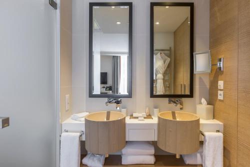 a bathroom with two sinks and a mirror at Hôtel Mont-Blanc Chamonix in Chamonix-Mont-Blanc
