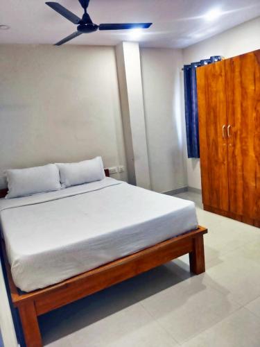 a bedroom with a bed with a ceiling fan at MS Comforts Mahadevapura in Bangalore