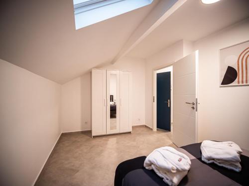 um quarto branco com 2 camas e uma clarabóia em Adalia Lodge em Basse-Yutz