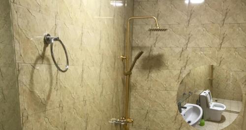 a bathroom with a shower with a toilet and a mirror at THE KEZA HOTEL near Kigali international airport. in Kigali