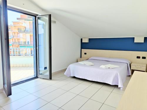 a bedroom with a bed and a large window at Rooms&Apartments Hotel Danci in Borghetto Santo Spirito