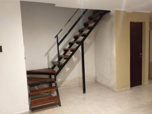 a wooden staircase in a room with a white wall at Pedro in Balcarce
