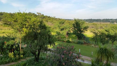 a garden with trees and a hill in the background at North Haven Country Estate in Honeydew